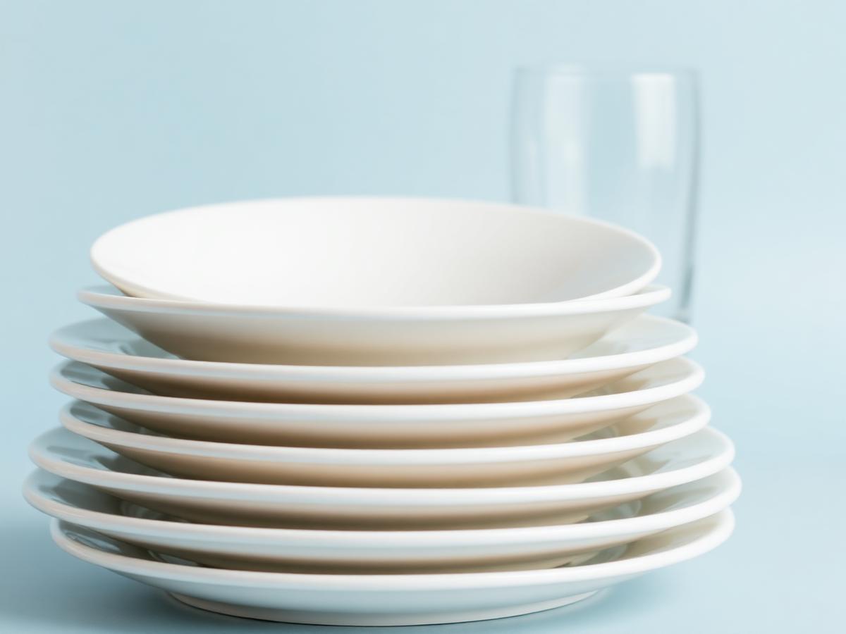 Stack of clean white plates and glassware